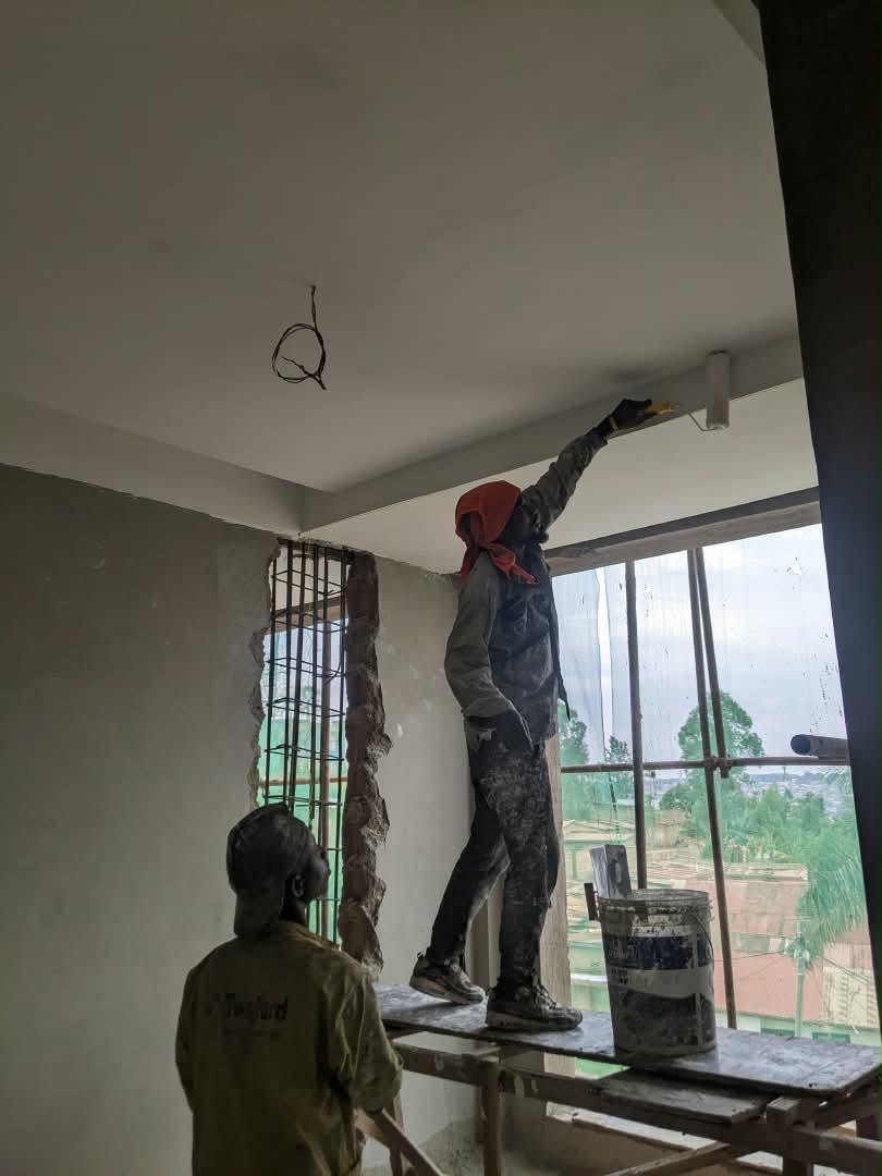 Painter finishing a ceiling at the Dhahabu Apartments site, September 2026